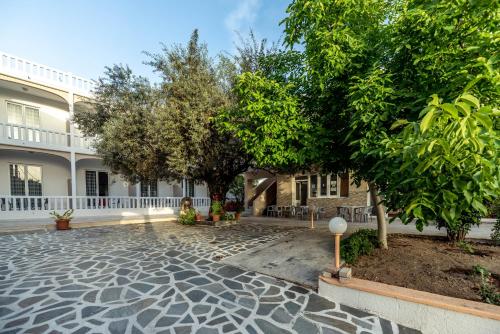 a courtyard with trees in front of a building at Hotel Ikaros in Archangelos