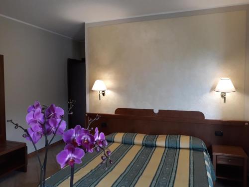 a bedroom with a bed with purple flowers on it at La Cascina Di Villa Due in Narzole