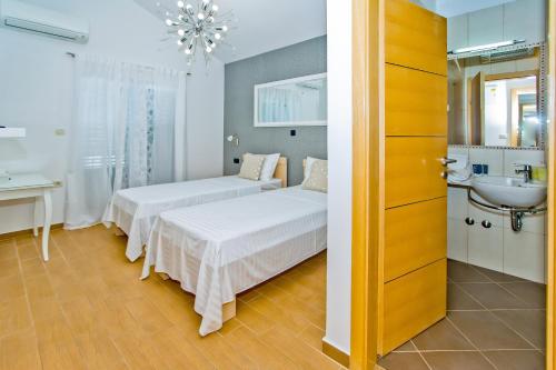 pokój hotelowy z dwoma łóżkami i umywalką w obiekcie Island Hvar Seaside Villa Levanda with Beach, Pool & Seaview w Hvarze