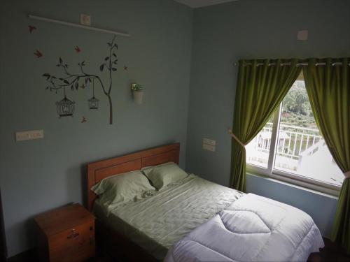 a small bedroom with a bed and a window at Honeybee residency Vagamon in Vagamon