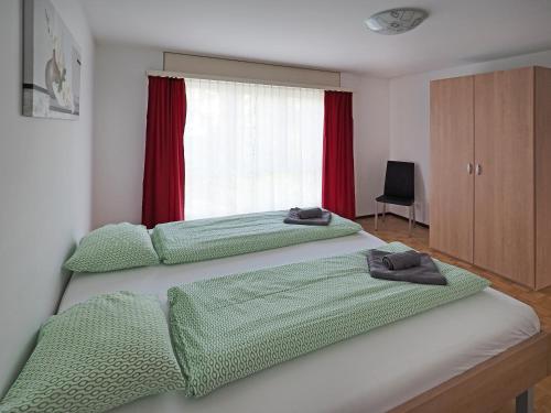 a bedroom with two beds with green sheets and a window at Apart Holidays - Residenza Flora in Locarno
