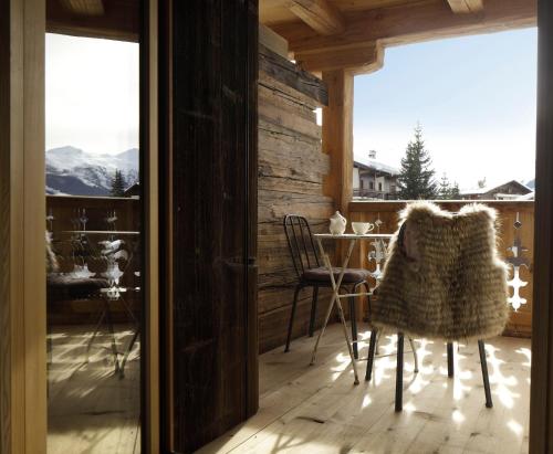 a room with a table and chairs on a balcony at La Cordée des Alpes SUP in Verbier