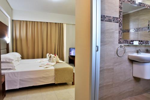łazienka z łóżkiem, umywalką i prysznicem w obiekcie Marathon Hotel - All Inclusive w Kolymbii
