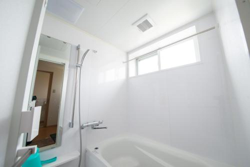a white bathroom with a mirror and a sink at Pine House in ISHIGAKI in Ishigaki Island