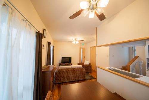 a living room with a couch and a ceiling fan at Pine House in ISHIGAKI in Ishigaki Island