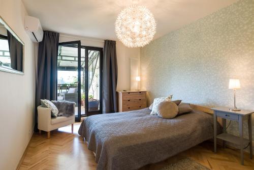 a bedroom with a bed and a chandelier at Kazimierz Apartment in Kraków