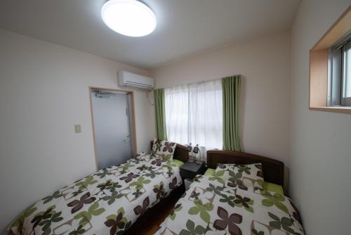 a bedroom with two beds and a window at Pine House in ISHIGAKI in Ishigaki Island