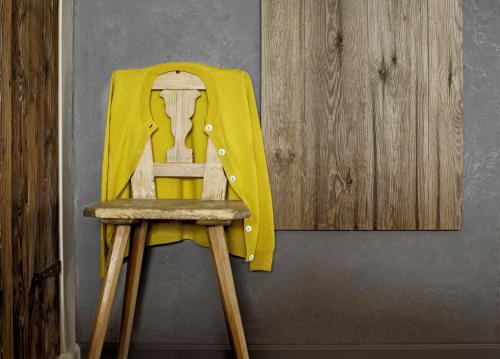 a yellow chair sitting next to a wall at La Cordée des Alpes SUP in Verbier