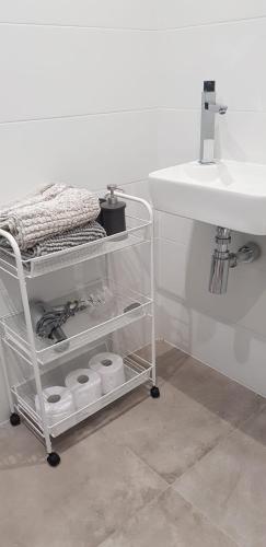 a bathroom with a sink and a cart with towels at Apt opposite the sea in Nerja