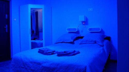 a blue bedroom with a bed with towels on it at Mini Studio in Augustów