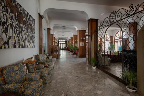 a hallway with couches and chairs in a building at Grand Hotel Excelsior in San Benedetto del Tronto