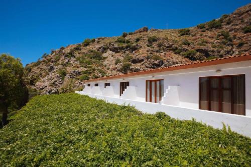 a row of white buildings in front of a mountain at Dionyssos Rooms Preveli Crete in Preveli