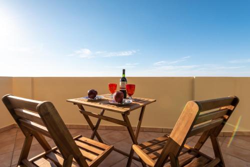 a table with a bottle of wine and two chairs at Anemos Villa in Sálakos