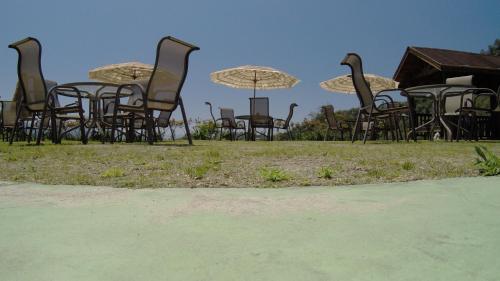 a group of chairs and umbrellas on a field at Yun Waterfall Valley Homestay in Fanlu