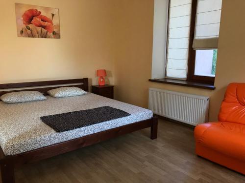 チョロノモスクにあるVeranda Guest Houseのベッドルーム1室(ベッド1台、オレンジ色のソファ付)