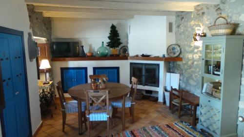 une salle à manger avec une table, des chaises et une cheminée dans l'établissement Vivienda rural fuente de los gusarapos, à Burunchel
