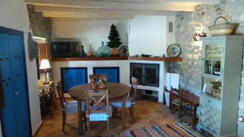 ein Esszimmer mit Tisch und Stühlen und einem Kamin in der Unterkunft Vivienda rural fuente de los gusarapos in Burunchel