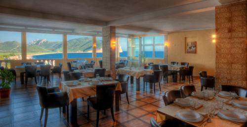 a restaurant with tables and chairs with mountains in the background at Castellamare Residence in Petrovac na Moru