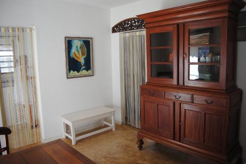 a large wooden cabinet in a room with a bench at Villa Palissandre in Nosy Be