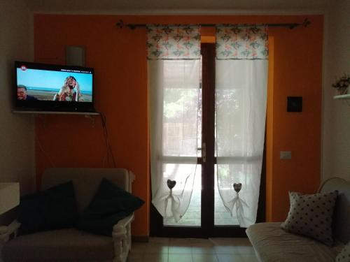 un soggiorno con TV e finestra di Casa Asfodelo Costa Rei a Costa Rei