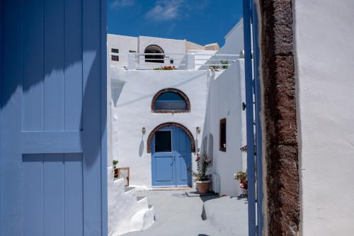 a blue door on a white building with stairs at Labyrinth Traditional Houses in Pirgos