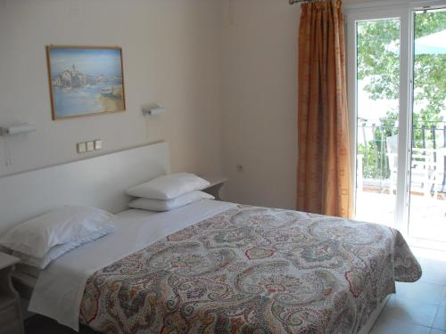 a bedroom with a bed and a large window at Hercules Sea Front Studios in Katelios