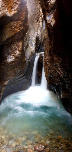 a waterfall in a canyon with a pool of water at Alpenlodge in Willigen