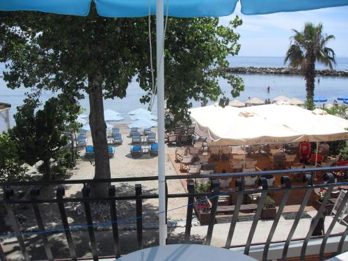 a view of a beach with tables and umbrellas at Hercules Sea Front Studios in Katelios