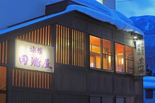 a building with a sign on the side of it at Tabataya in Myoko