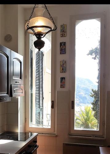 a kitchen with a chandelier and a large window at Elegant and Sea View Excelsior Apartment in Levanto