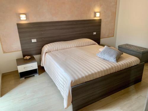 a bedroom with a large bed with a wooden headboard at Sweet Home in Francavilla di Sicilia