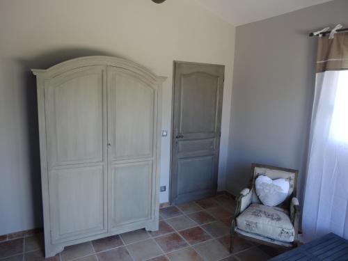 a room with a white cabinet and a chair at Mas'Xime in Saint-Rémy-de-Provence