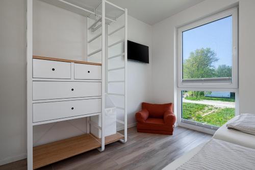 a bedroom with a bed and a dresser and a window at Ferienhaus Rügen-Relax in Trent