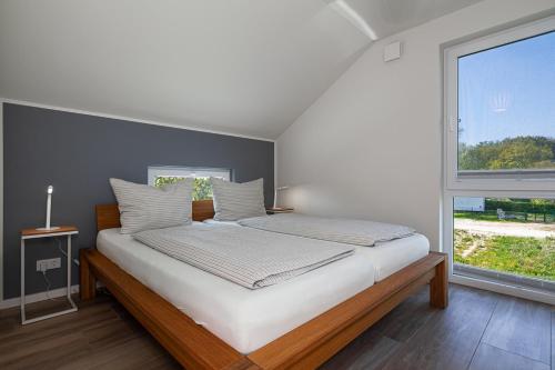 a bed in a room with a large window at Ferienhaus Rügen-Relax in Trent