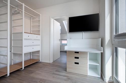 a white bedroom with a tv on a wall at Ferienhaus Rügen-Relax in Trent