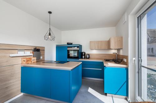 a kitchen with blue cabinets and a blue island at Ferienhaus Rügen-Relax in Trent