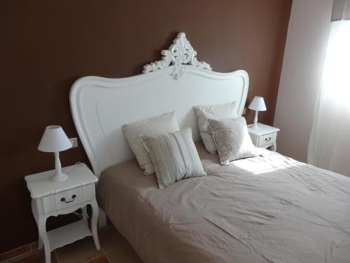 a white bed with two white tables and two lamps at Mas'Xime in Saint-Rémy-de-Provence