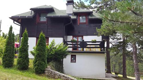 a black and white house with a white garage at Vila Jelena, Tara in Kaludjerske Bare