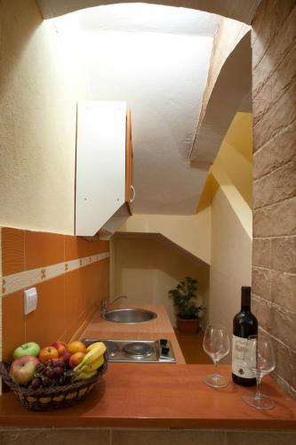 a kitchen with a bowl of fruit and two wine glasses at Castellamare Residence in Petrovac na Moru