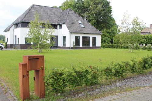 a house with a sign in front of a yard at De Weije Wereld in Sint-Oedenrode