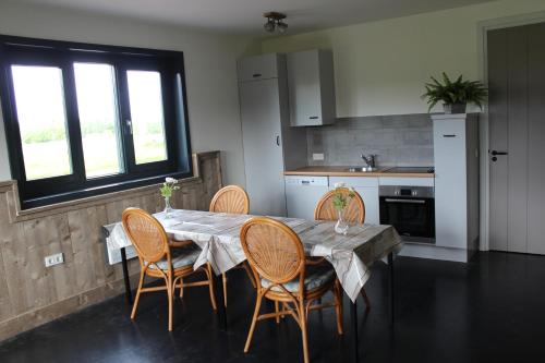 a dining room with a table and chairs in a kitchen at De Weije Wereld in Sint-Oedenrode