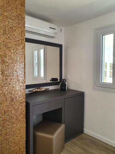 a bathroom with a vanity with a mirror and a stool at Mykonos Double Luxury Mini Suites-With External Hot spa Adults only in Ano Mera