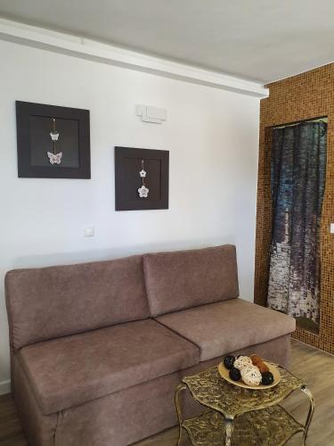 a living room with a brown couch and a table at Mykonos Double Luxury Mini Suites-With External Hot spa Adults only in Ano Mera