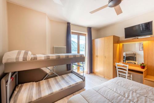 a bedroom with two bunk beds and a desk at Hotel Argegno in Argegno