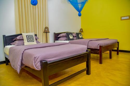 two beds in a room with a balloon in the background at Richards Cabanas in Tissamaharama