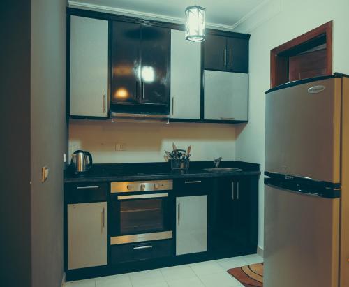 a kitchen with black cabinets and a stainless steel refrigerator at Pool View One bedroom Apt - B103 in Hurghada