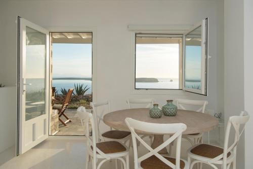 een witte eetkamer met een tafel en stoelen bij Meltemi Seaside in Kampos Paros