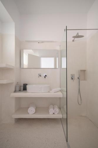 a white bathroom with a sink and a shower at Meltemi Seaside in Kampos Paros