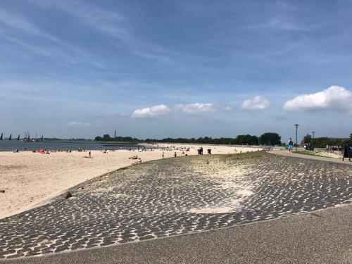 a beach with a bunch of people on the sand at Marina Strand Appartement Lemmer in Lemmer