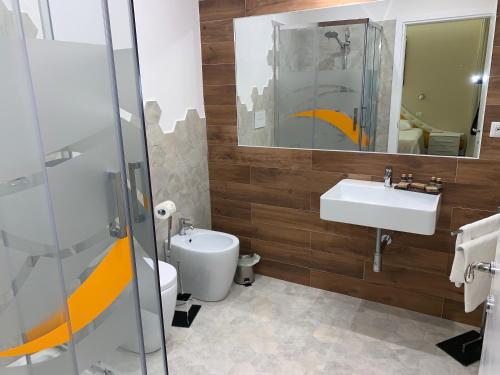 a bathroom with a sink and a toilet and a mirror at 7 Bell's House in Civitavecchia